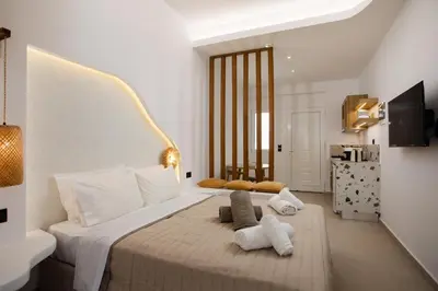 a bedroom with a large bed with towels on it at Stay Helios in Faliraki