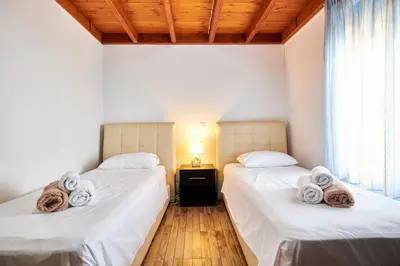 two beds in a room with towels on them at Nerida Beachfront Villas in Plimmiri