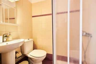 a bathroom with a toilet and a sink and a shower at Nerida Beachfront Villas in Plimmiri