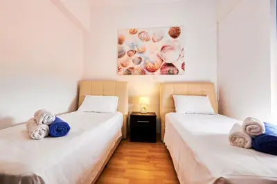 two beds in a room with towels on them at Nerida Beachfront Villas in Plimmiri