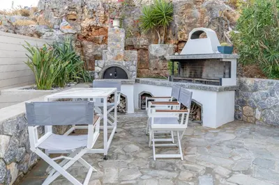 a patio with a table and chairs and a stove at Lindos 4 me Apartment in Líndos