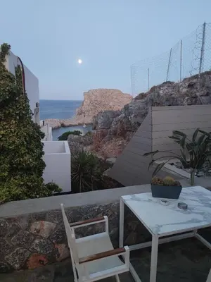 a table and chairs on a balcony with the ocean at Lindos 4 me Apartment in Líndos