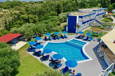an aerial view of a resort with a swimming pool and blue umbrellas at Summer View in Theologos