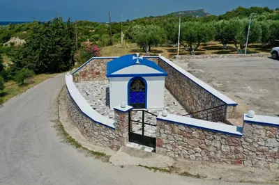 a stone wall next to a road at Summer View in Theologos