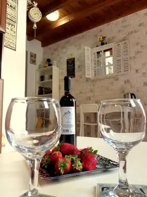 two wine glasses sitting on a table with strawberries at The White House of Rhodes in Rhodes Town