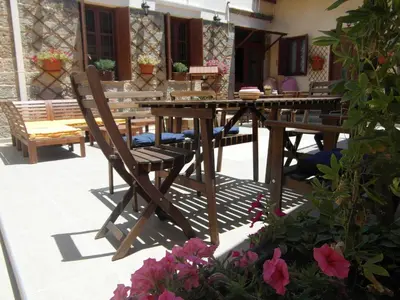 a wooden table and chairs on a patio with flowers at The White House of Rhodes in Rhodes Town