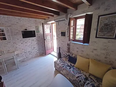 a living room with a couch and a tv at The White House of Rhodes in Rhodes Town