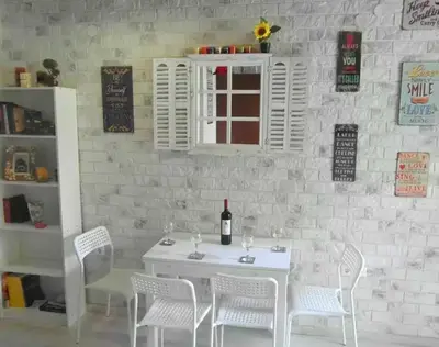 a white table with white chairs and a bottle of wine at The White House of Rhodes in Rhodes Town
