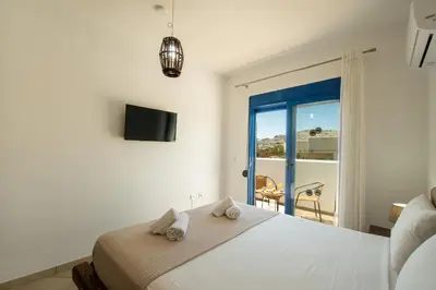 a bedroom with a bed with a view of a balcony at Maripaul Family Villa in Lardos
