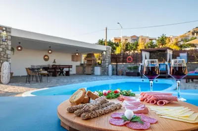a table with a tray of food and wine glasses at Maripaul Family Villa in Lardos