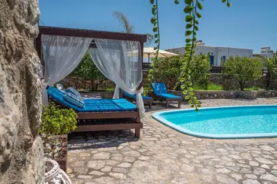 a patio with a swing and a swimming pool at Maripaul Family Villa in Lardos
