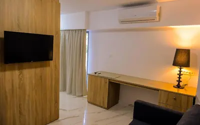 a room with a desk with a television on a wall at Island Dreams Rooms & Suites in Rhodes Town