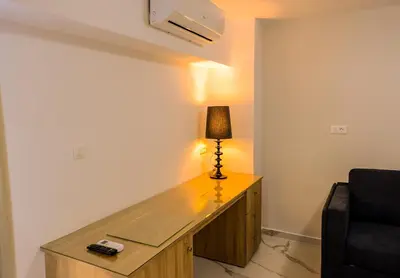 a room with a desk with a lamp and a chair at Island Dreams Rooms & Suites in Rhodes Town