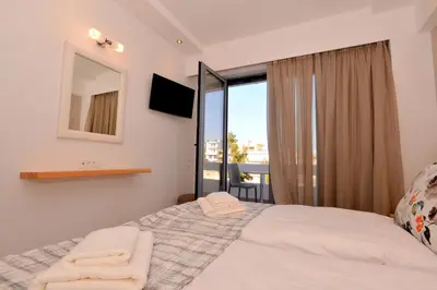 a bedroom with a bed with a mirror and a window at Island Dreams Rooms & Suites in Rhodes Town