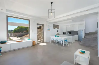 a kitchen and living room with a table and chairs at Villa Olympos in Afantou