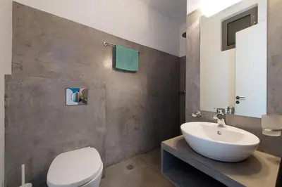 a bathroom with a white toilet and a sink at Villa Olympos in Afantou