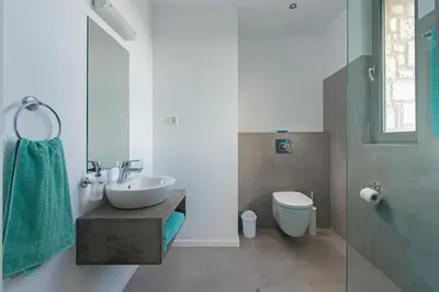 a white bathroom with a sink and a toilet at Villa Olympos in Afantou