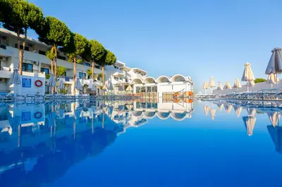 a view of a hotel with a reflection in the water at Rodos Star Hotel in Afantou
