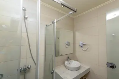 a bathroom with a sink and a glass shower at Rodos Star Hotel in Afantou
