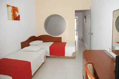 a bedroom with two beds and a mirror at Rodos Star Hotel in Afantou