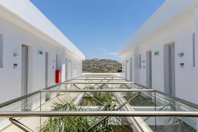 a glass walkway in a building with plants at Rodos Star Hotel in Afantou