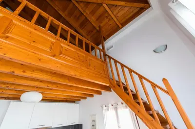 a wooden staircase in a room with a ceiling at Myrtia in Symi