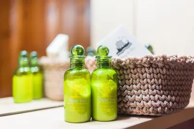 two bottles of olive lime on a counter with a basket at Myrtia in Symi