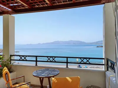 a view of the beach from a balcony with a table and chairs at Haraki Village in Haraki