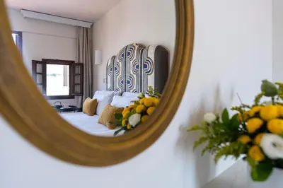 a mirror reflection of a bed in a room at Maris Lindos Suites & Apartments in Líndos
