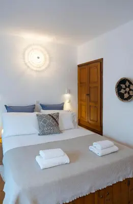 a bedroom with a large bed with two towels on it at Maris Lindos Suites & Apartments in Líndos
