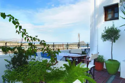 a balcony with a table and chairs and plants at Maris Lindos Suites & Apartments in Líndos