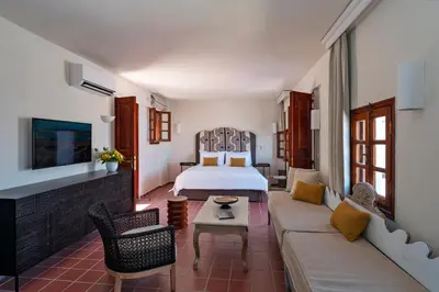 a hotel room with a bed and a couch at Maris Lindos Suites & Apartments in Líndos