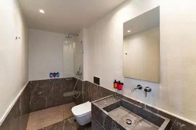 a bathroom with a sink and a toilet and a mirror at Maris Lindos Suites & Apartments in Líndos