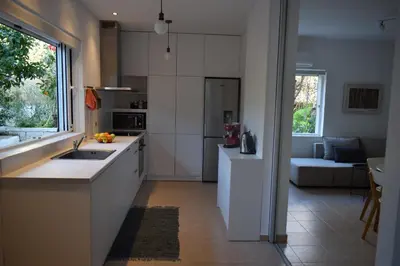 a white kitchen with a sink and a couch at Blugreen Stegna Suites and Apartments in Archangelos