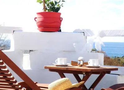 a table with two cups and a pot on a wall at Blugreen Stegna Suites and Apartments in Archangelos