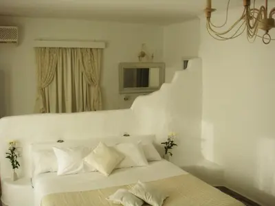 a white bed with white pillows in a bedroom at Blugreen Stegna Suites and Apartments in Archangelos