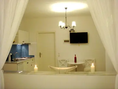 a kitchen with a table and a dining room with candles at Blugreen Stegna Suites and Apartments in Archangelos