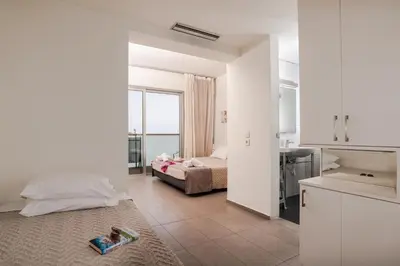 a bedroom with a bed and a kitchen with a window at Atlantis Boutique City Hotel in Rhodes Town