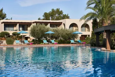 a resort with a swimming pool with chairs and umbrellas at Aquagrand Artistic Luxury Beach Resort - Adults Only in Líndos