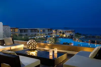 a patio with a view of a pool at night at Aquagrand Artistic Luxury Beach Resort - Adults Only in Líndos