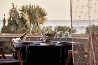a table with glasses and a bottle of wine on it at Aquagrand Artistic Luxury Beach Resort - Adults Only in Líndos