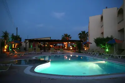 a swimming pool in a hotel at night at Sevastos Studios in Faliraki