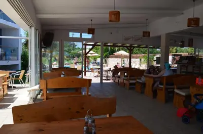 a restaurant with tables and chairs and people sitting at tables at Sevastos Studios in Faliraki