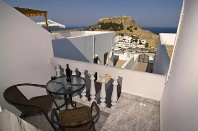 a table and chairs on a balcony with a view at Lindos Panorama in Líndos