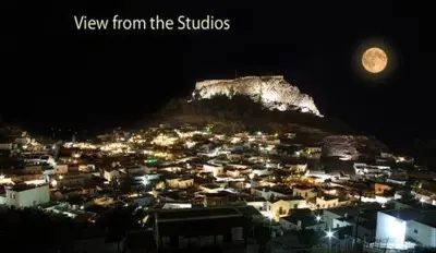 a view of a city at night with the moon at Lindos Panorama in Líndos