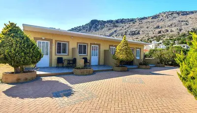 a yellow house with trees in front of it at George Studios Pefkos in Pefki Rhodes