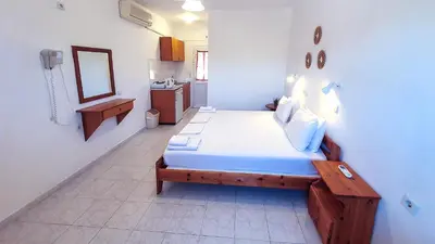 a bedroom with a bed and a mirror on the wall at George Studios Pefkos in Pefki Rhodes