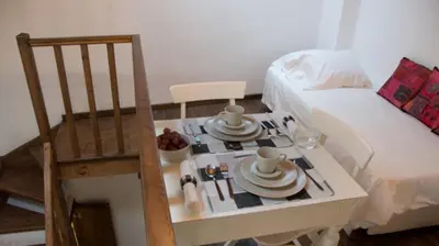 a small table with dishes on it next to a bed at Domus Studios in Rhodes Town