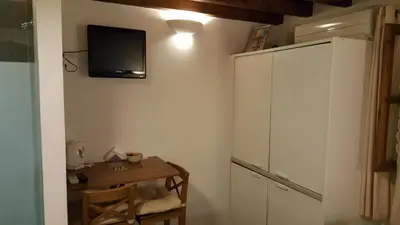 a room with a cabinet and a tv on the wall at Domus Studios in Rhodes Town