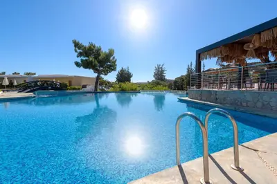 a large swimming pool with blue water at Porto Angeli in Archangelos